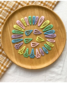 Gros plan de barrettes à cheveux colorées macaron en forme d'étoile et de cœur
