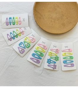 Détail macro de barrettes macaron colorées en forme de cœur et d'étoile sur carte