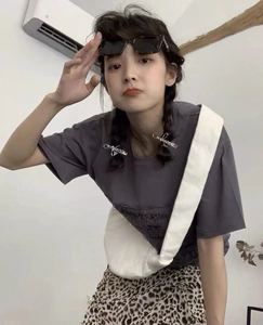 Close-up of a silver bow metal hair clip worn by a model in a casual daily outfit