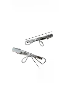 Detail of a 7cm minimalist silver metal bow hair clip with duckbill clamp design