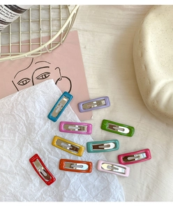 Macro shot of 10 colorful candy-toned rectangular metal BB hair clips for kids
