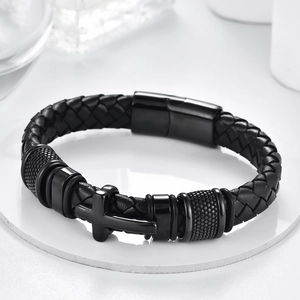 Close-up of black braided leather bracelet featuring a matte cross and magnetic buckle