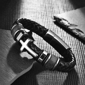 Close-up of men's braided leather bracelet with steel cross charm and textured metal beads
