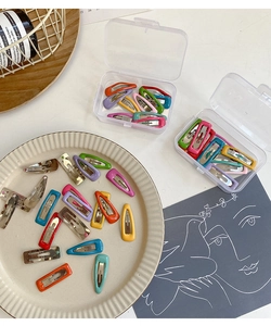 Close-up of colorful drip oil metal hair clips with transparent storage cases for kids