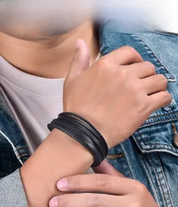 Close-up of multilayer black woven leather bracelet with stainless steel clasp on wrist