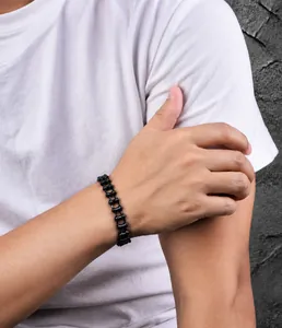 Detail van een zwarte punk fietsketting armband van titanium staal om een pols van model