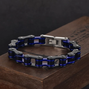 Detail of blue and black bicycle chain bracelet on a vintage wooden box background