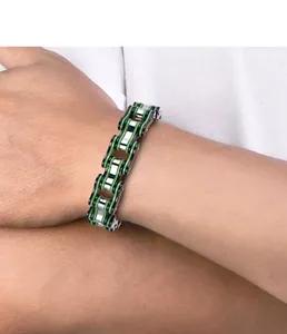 Detail of silver and green stainless steel punk bike chain bracelet on male wrist