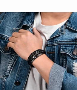 Nahaufnahme eines Herren-Lederarmbands mit Ankeranhänger auf einer Jeansjacke getragen