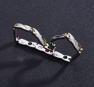 Detail of men's magnetic therapy bracelet with gold-tone accents and textured links