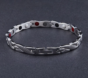 Detail of men's stainless steel magnetic bracelet with snake skin texture and colored inserts
