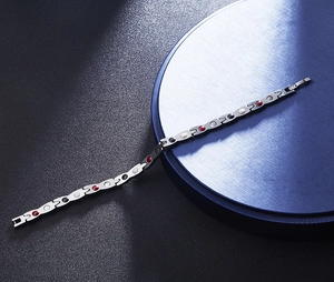 Macro detail of men's steel bracelet showing magnetic elements and gold-tone snake pattern