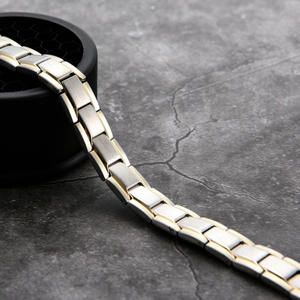 Macro shot of a brushed silver and gold stainless steel magnetic link bracelet