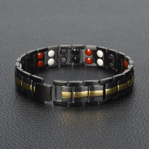 Close-up of double row black and gold magnetic therapy bracelet with inset stones