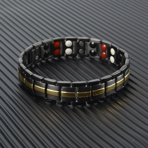 Detail of men's magnetic steel bracelet with dual-row black and gold linked links