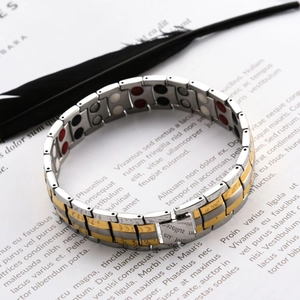 Detail of men's magnetic steel bracelet with two-tone finish and functional inlay beads