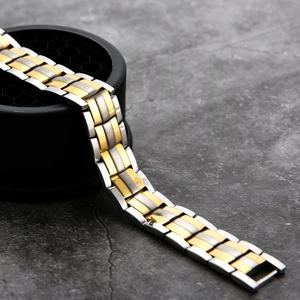 Detailed close-up of two-tone stainless steel magnetic bracelet with polished links