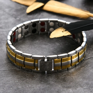 Detailed macro view of two-tone magnetic health bracelet with golden accents and metal links
