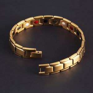 Detailed view of the golden magnetic therapy bracelet with inset energy stones