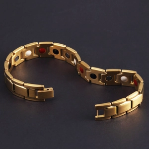Close-up of golden magnetic energy bracelet with brushed finish and colorful stones