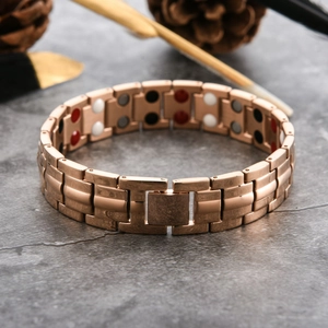 Macro view of rose gold magnetic therapy bracelet with four-color energy stones on inner band
