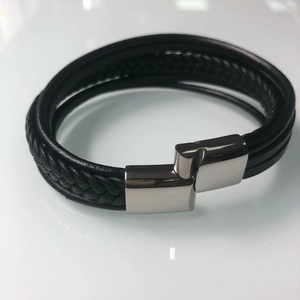 Detail view of multi-layer black leather bracelet with silver magnetic metal clasp