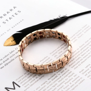 Detailed macro view of rose gold magnetic therapy bracelet with colorful functional magnets