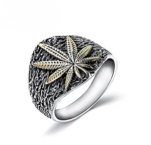 Detail of vintage men's silver band ring featuring a golden leaf motif and rock texture