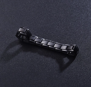 Detail view of 12mm matte black stainless steel magnetic links on a dark textured surface