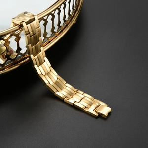 Detail of golden stainless steel magnetic bracelet with brushed finish and fold-over clasp