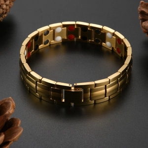 Detail of gold brushed stainless steel magnetic therapy bracelet with tri-color functional beads