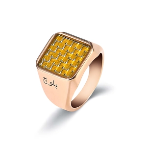 Detalle de anillo de sello en oro rosa con incrustación de rejilla amarilla y grabado