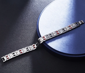 Detail of titanium steel magnetic bracelet featuring red and black energy stone inserts
