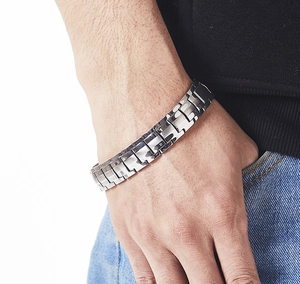 Close-up of a men's silver stainless steel link bracelet on a model's wrist