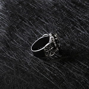 Détail macro d'une bague gothique en acier inoxydable avec gravure en relief et motif croix