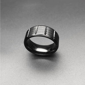 Detailed view of men's matte black stainless steel ring with geometric groove accents