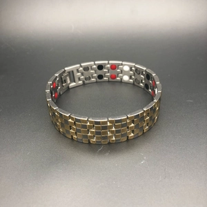 Detailansicht eines Herren-Magnetarmbands aus Stahl mit roten, schwarzen und weißen Steinen