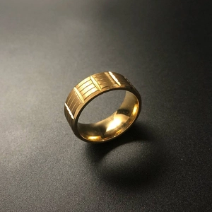 Macro shot of men's gold plated stainless steel ring with vertical textured grooves