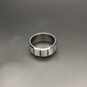 Detailed view of dark grey matte stainless steel men's ring with textured grid pattern