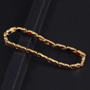 Bracciale magnetico in acciaio inossidabile dorato su sfondo di pietra nera