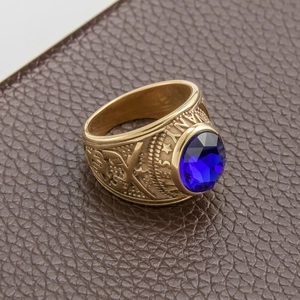 Close-up of golden military ring with blue oval gemstone and embossed side details
