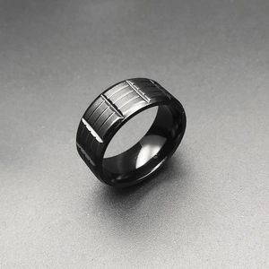 Men's black stainless steel ring with industrial tire tread texture and matte finish