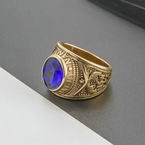 Detail of vintage gold military style ring featuring a blue gemstone and ornate side engravings