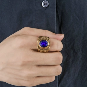 Detail of gold military ring with oval blue gemstone and United States Navy engraving