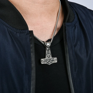 Macro detail of Mjolnir pendant necklace on model showing intricate Celtic relief texture