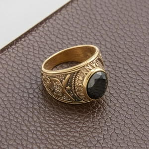 Detail of vintage gold military ring with oval black stone and intricate side carvings