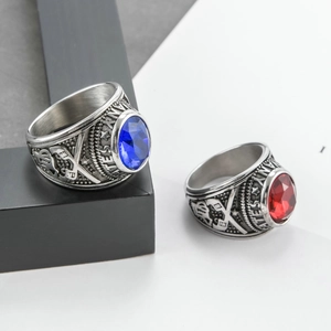 Detail view of military rings with blue and red stones and navy anchor engraving