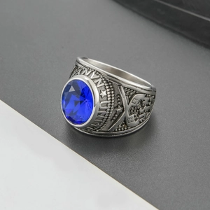 Macro view of vintage stainless steel military ring with faceted blue gemstone and star carvings
