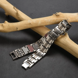 Detalle de pulsera magnética de titanio sobre ramas mostrando elementos terapéuticos