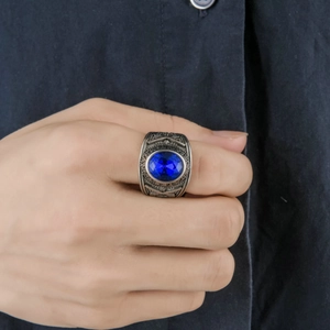 Close-up of vintage silver alloy ring featuring a large blue oval rhinestone and relief detail